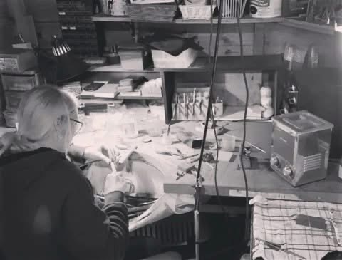 Kerry working at the jewellery bench, tools and materials spread under the lamp